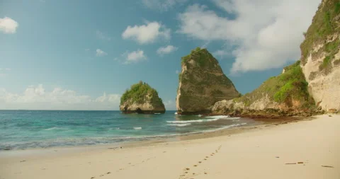 Footprints lead across the pristine white sand of Diamond Beach in Nusa Penida Stock Footage 341293106