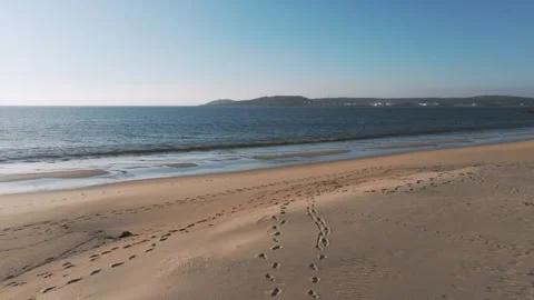 Footprints Left On The Sand At Praia do Lago With Lighthouse Stock Footage 310832323