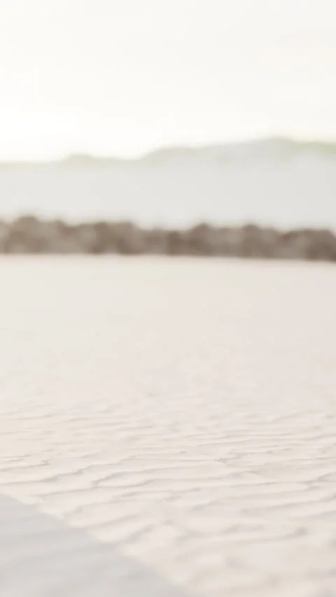 Footprints in sand on a beach during early morning light with soft waves Stock Footage 337929724