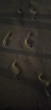 Footprints on the sand at night Stock Photos