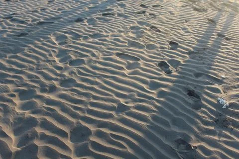 Footprints on Sand Ripples Pattern at Sunset Beach Stock Photos
