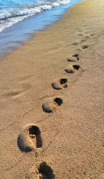 Footprints on the sandy beach Stock Photos