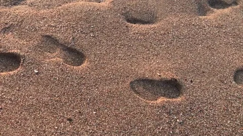 Footprints in the sea sand Stock Footage