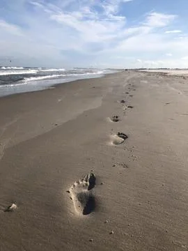 Footsteps on a beach on a beautiful day Stock Photos