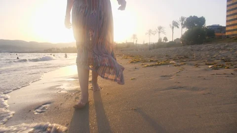 Footsteps on Sandy Beach with Sunset Flare. Woman Walking by Waves on Seaside Stock Footage 94498429