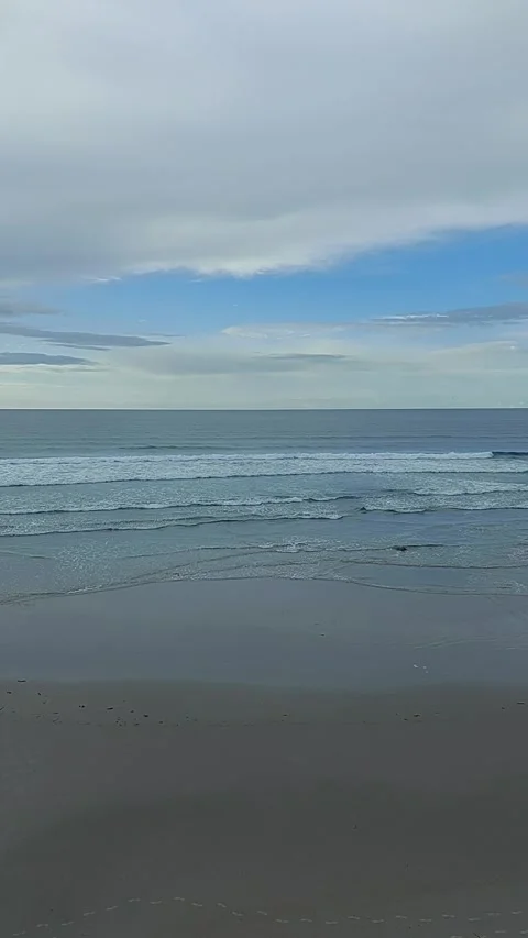 Footsteps on the seashore of Os Castros beach with calm Atlantic waves in Ga Video stock 337323582