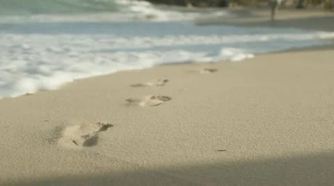 Footsteps washed away on beach-RevoStock Stock Footage 11335451