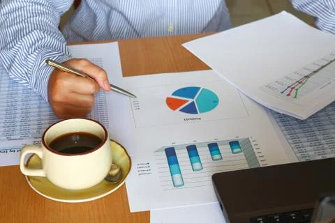 Forcasting and analyzing sales charts and graphs report with coffee cup Stock Photos