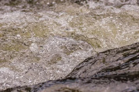 The force of the current forms bubbles on the surface of the water Stock Photos