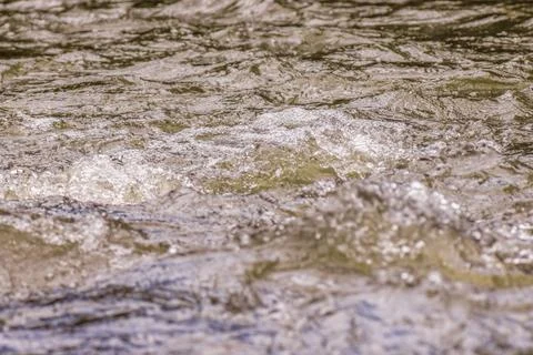 The force of the current forms bubbles on the surface of the water Фото