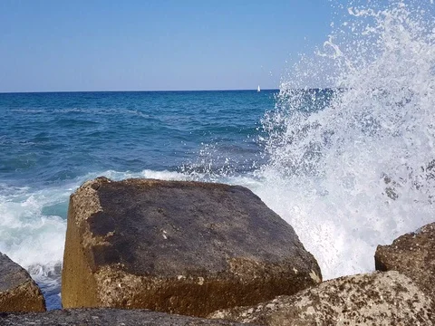 Force of nature. Splashing wave energy. Splash as sea water hits concrete rock Video stock 77969427
