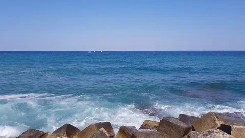 Force of nature. Splashing wave energy. Splash as sea water hits concrete rock Video stock 77969616