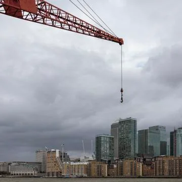 Forced perspective makes a crane appear gigantic over Canary Wharf Stock Photos