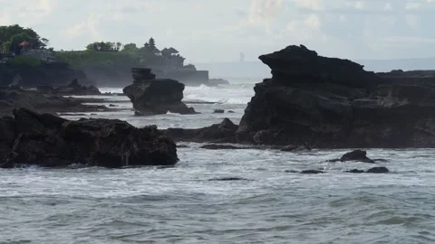 Forceful Surf Collides With Sharp Rocks Under Foggy Spray And Temple Silhouette Video stock 332617130
