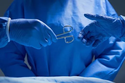 Forceps please. Closeup shot of group of surgeons working on a patient in an Stock Photos