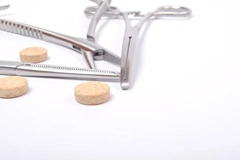 Forceps with tablets on white Stock Photos