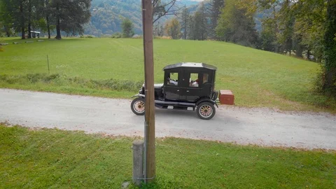 Ford Model T with suitcase, driving down macadam tree lined avenue Stock Footage 121222017