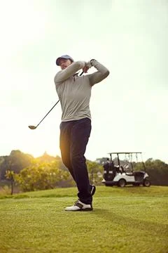 Fore. Full length shot of a young man swining a golf club while enjoying a day Stock Photos