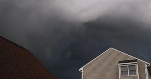 Foreboding dark thick storm clouds above houses before torrential downpour rain 스톡 동영상 207928598
