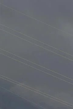Foreboding industrial scene under threatening clouds and crossing wires Stock Photos