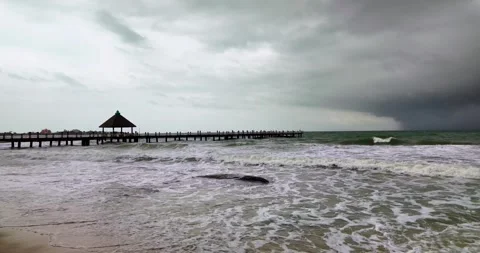 Foreboding storm clouds gather over a wooden pier in a choppy sea. Stock Footage 313797487
