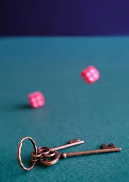 In the foreground is bunch of of house keys. Red dices and leather cup, cards Stock Photos