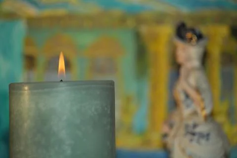 In the foreground a burning candle, extremely blurred background Foto stock