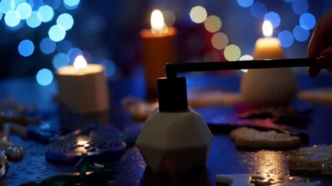In the foreground, a candle is extinguished with a special object. Stock Footage 263809458