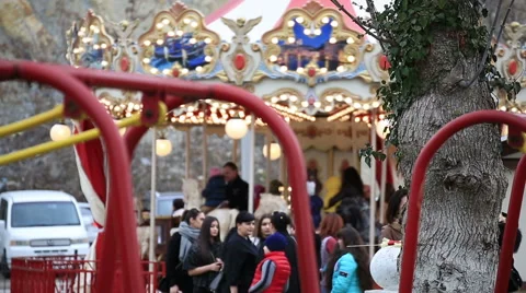 Foreground - children swinging on a swing, background - carousel Stock Footage 67363161