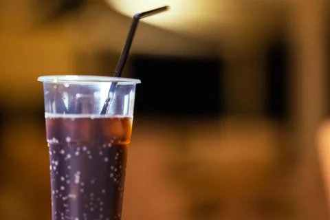 In Foreground In Focus Is Plastic Cup With Dark Cold Drink And Black Straw, In Stock Photos