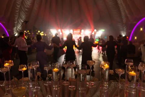 Foreground focus transparent vases decor on glass table at disco party Stock Photos