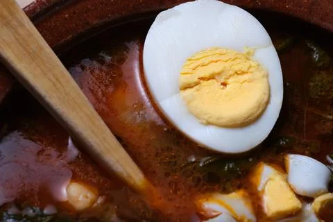 Foreground of hard-boiled egg in an earthenware casserole Stock Photos