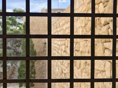 Foreground iron grid with distant scenery, Closeup of iron mesh against blurred Stock Photos