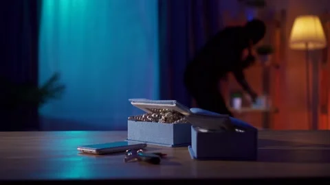In the foreground the jewels are lying on the table and behind the robber with a Stock Footage 155144127