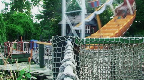 In the foreground a network woven from a large rope swing which sways from side Vídeos de archivo 67978857