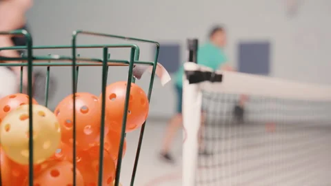 Foreground pickleballs with players in the background Stock Footage 299438734
