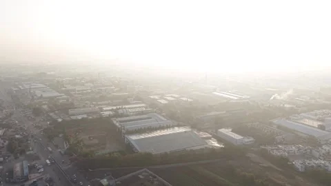 The foreground reveal factory complex next to an empty brown plot of land Stock Footage 331559087