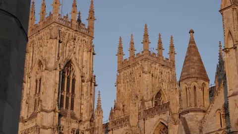 Foreground reveal of top section and spires of huge cathedral York Minster Stock Footage 168067533