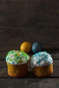 In the foreground there are 2 Easter cakes, in the back there are Painted egg Stock Photos