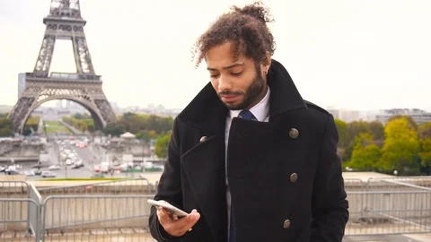 Foreign student in Paris calling with smartphone near Eiffel Tower in slow Stock Footage 82806065