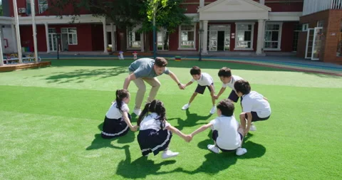 Foreign teacher and students playing in kindergarten playground,4K Video stock 146828744