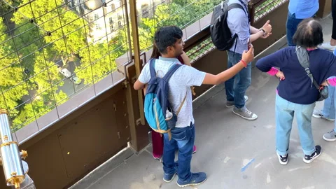 Foreign tourists taking a selfie while visiting the Eiffel Tower in Paris Stock Footage 196153918