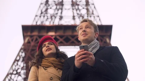 Foreign tourists watching online map on smartphone searching for sights in Paris Stock Footage 83902968