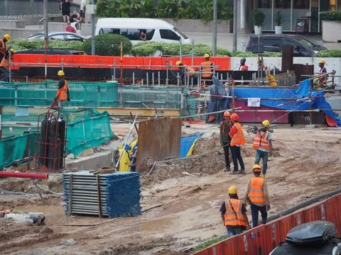 Foreign workers are working in a construction site Foto stock