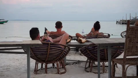 Foreigners chilling on the beach  Stock Footage 130398102