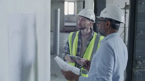 Foreman and Architect Discussing Floor Plans at Construction Site Stock Footage 332249408