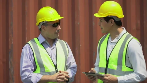 Foreman and asian harbor worker discussion and using digital tablet checking Stock Footage 154690901
