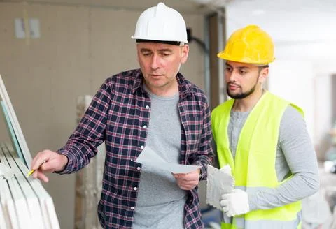 Foreman and builder counting construction materials 写真素材