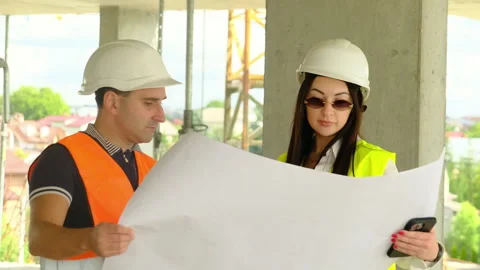 Foreman and engineer discuss blueprint of special project Stock Footage 317620561