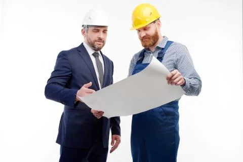 Foreman and engineer looking at a drawing on a white background Stock Photos